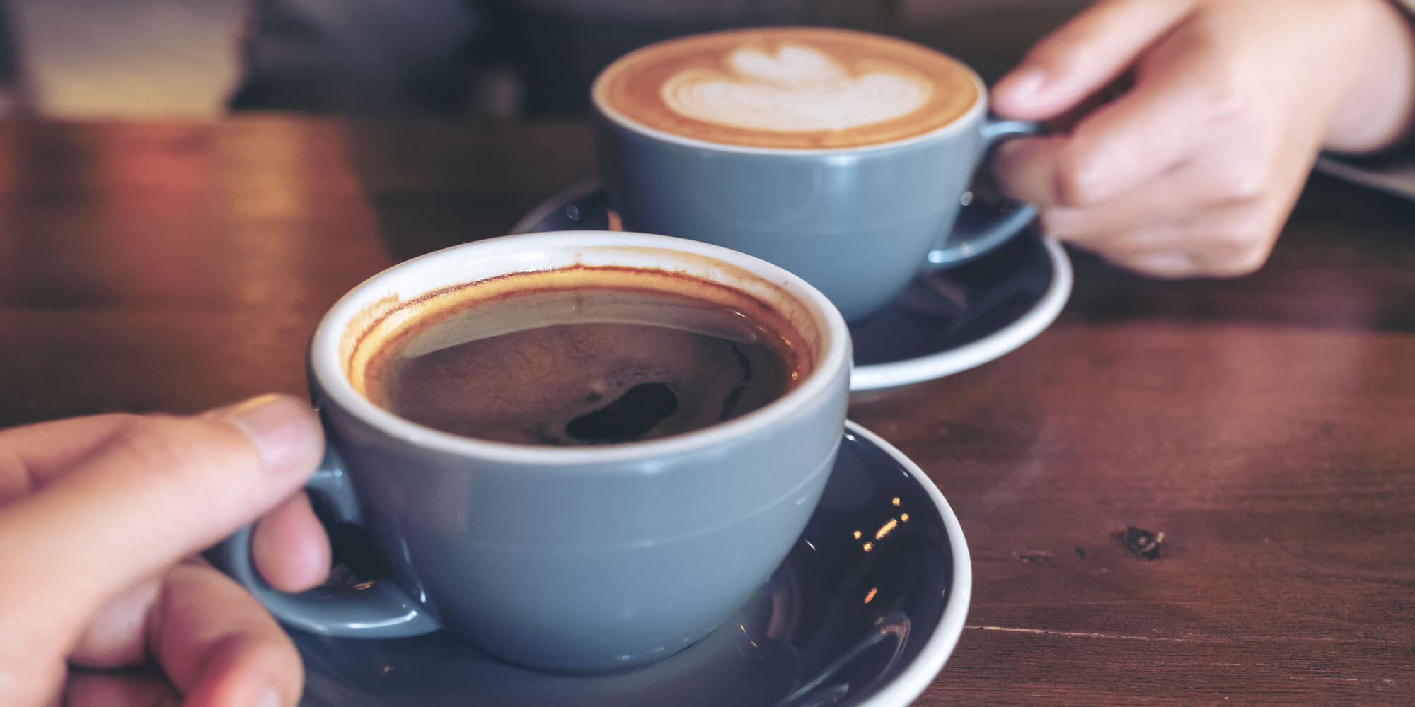 Close Up Image Of A Man And A Woman Clinking Blue Coffee Mugs On